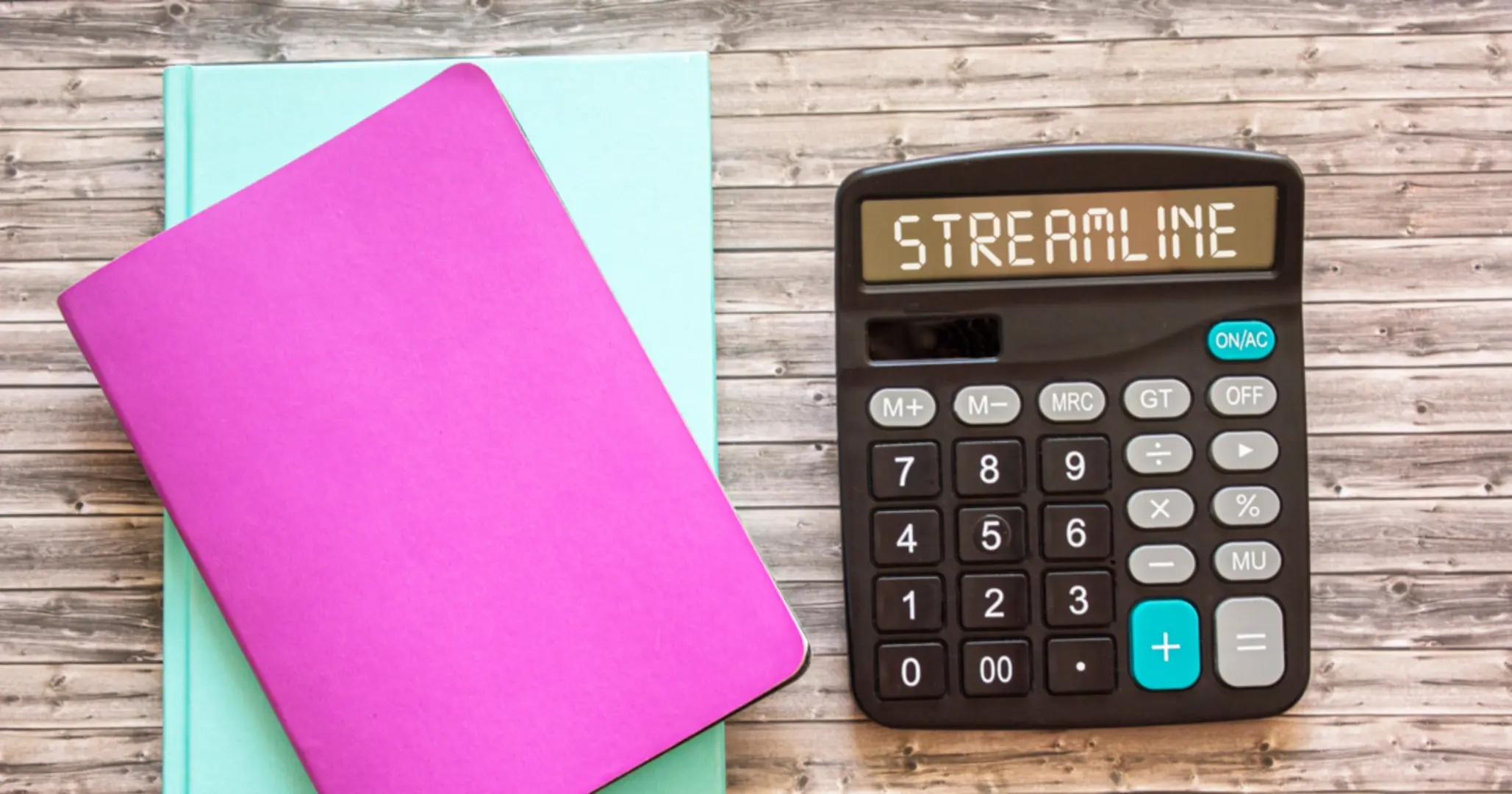 Pink and blue notebooks stacked on each other, with a calculator to the right of them that reads "streamline"