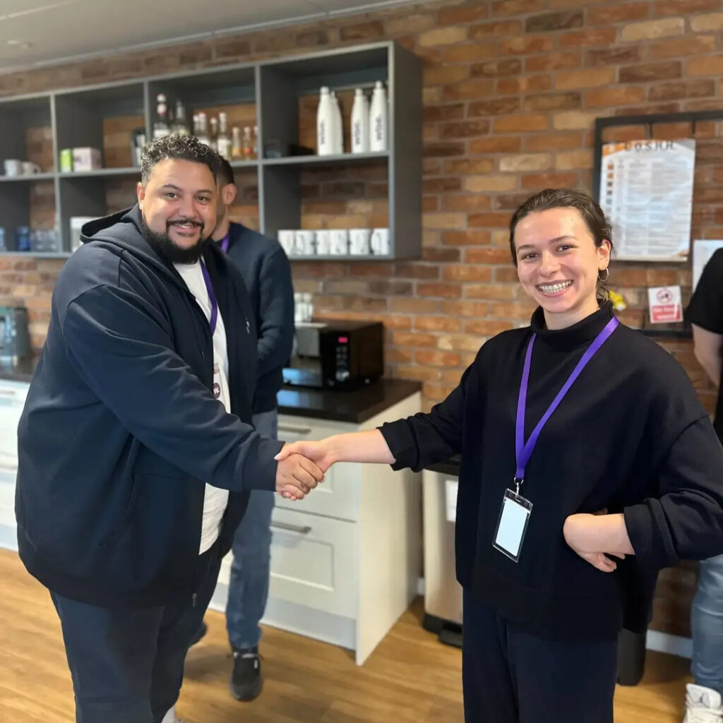 One of the Davids from the Council of Davids shaking the winner's hand.