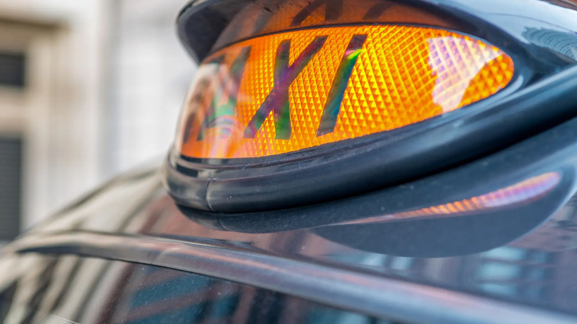 A taxi sign on a black London taxi